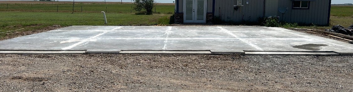 Concrete pad showing a saw cut and inset garage door opening detail