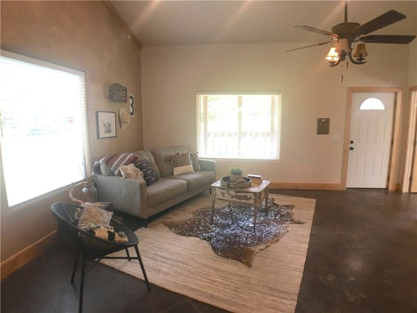 TBC project photo of a finished living room with seating, vaulted ceiling, and polished floor.