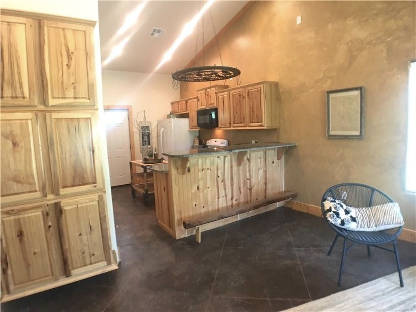 TBC project photo of a finished interior with wood cabinetry and vaulted ceiling.