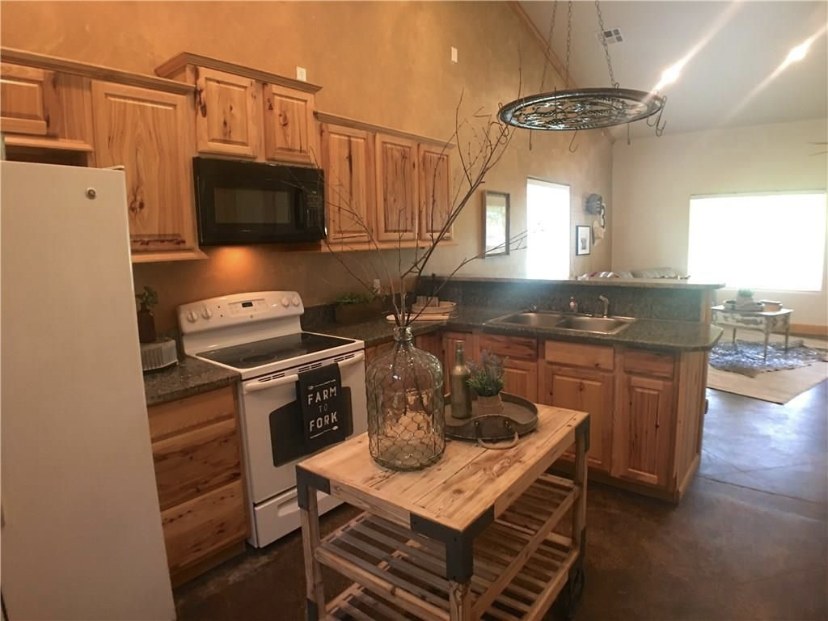 TBC project photo of a finished kitchen with wood cabinetry and vaulted ceiling.