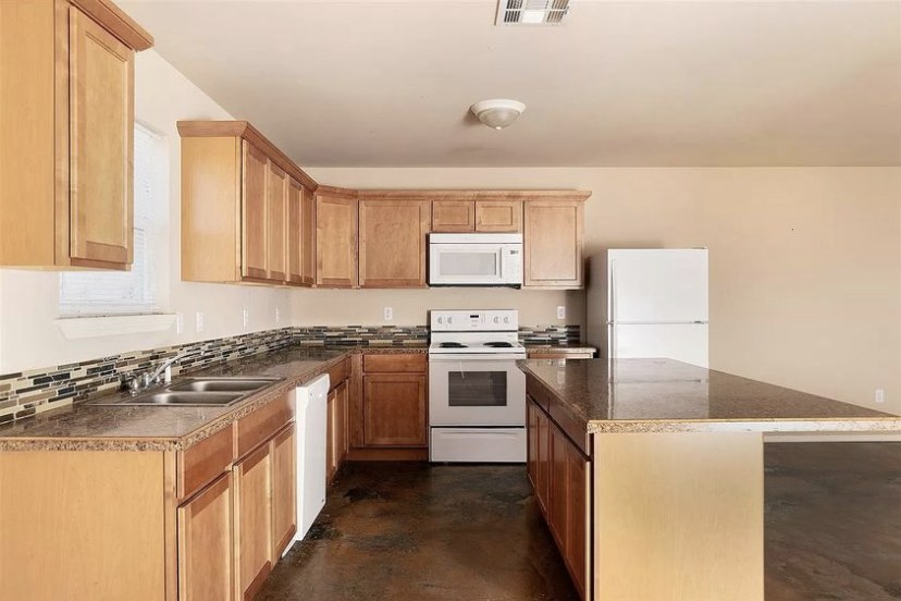 TBC project photo of a finished kitchen with wood cabinets and counters.