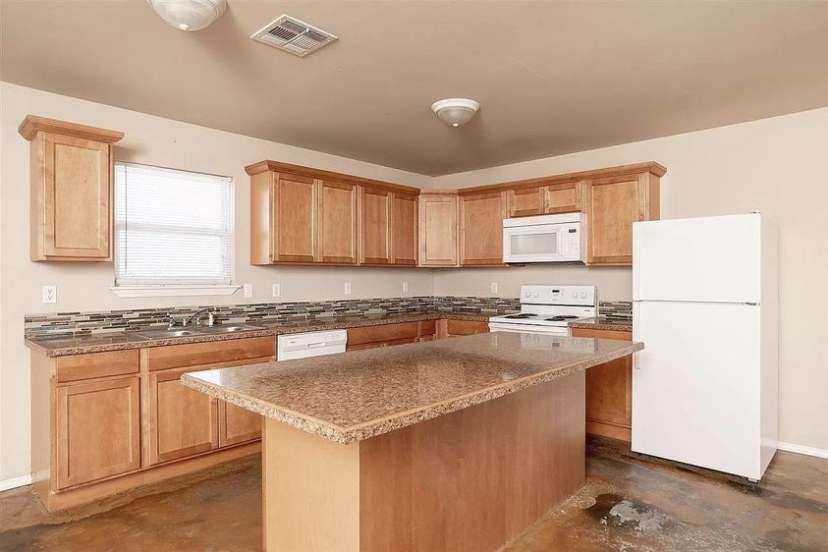 TBC project photo of a finished kitchen with wood cabinets and counters.