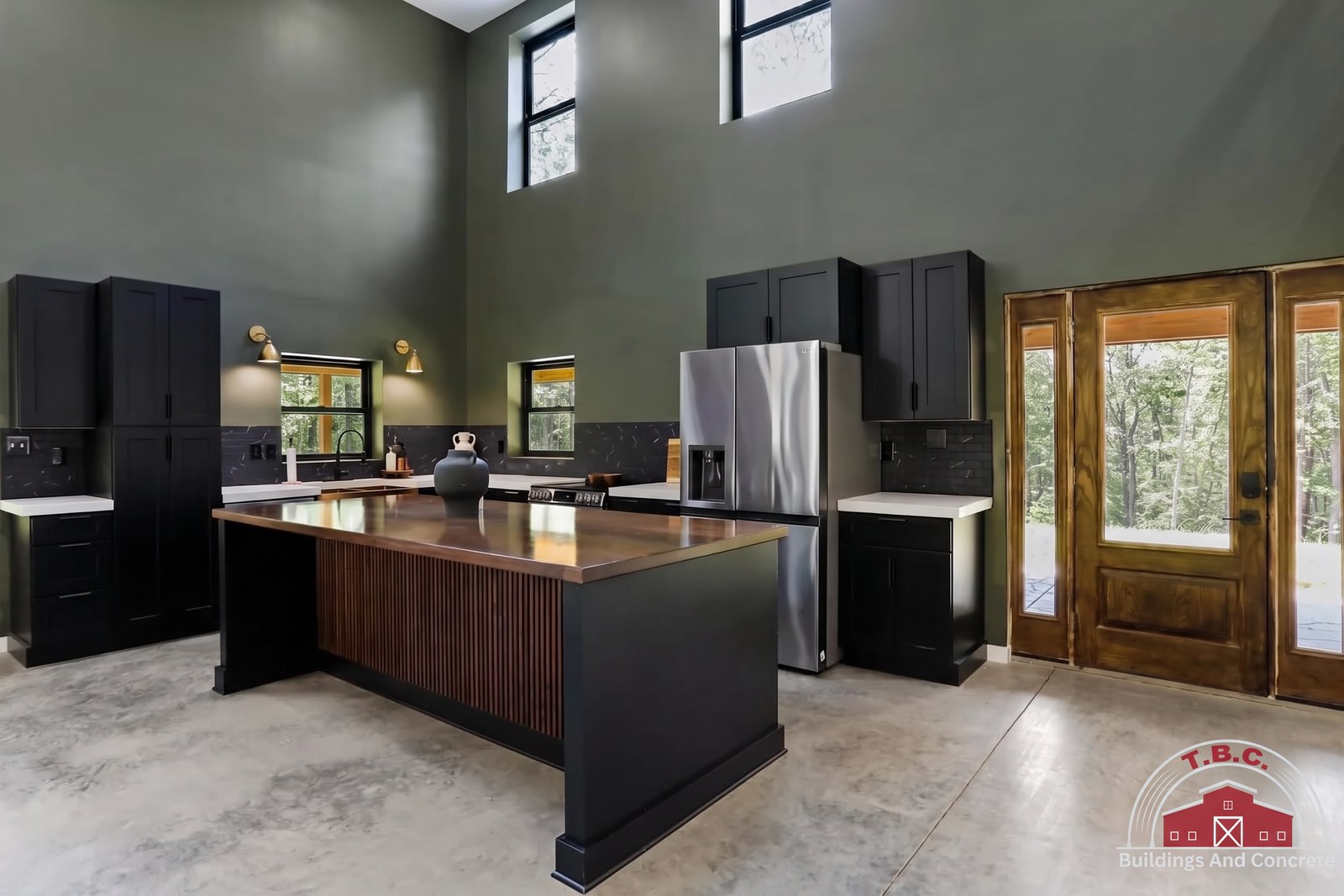 TBC project photo of a kitchen with dark cabinets, a wood-topped island, a refrigerator, and glass French doors.