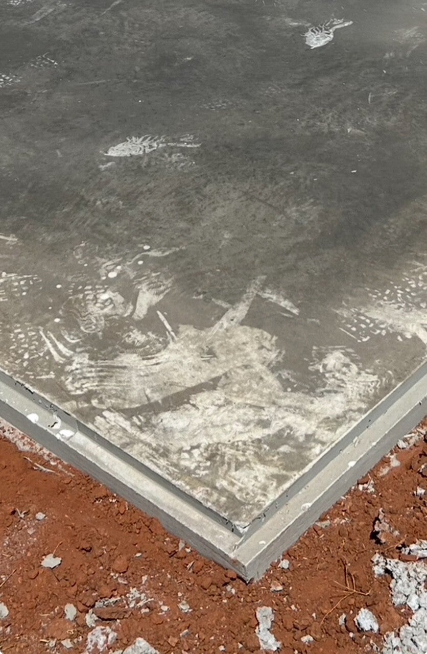 Concrete building pad with a visible metal perimeter lip at the slab edge